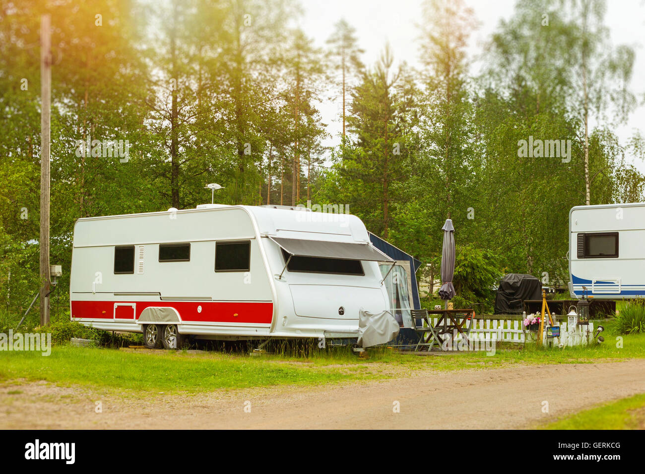 Estate di attività ricreative all'aperto, scandinavo vacanza in casa su ruote. Camping furgoni e tende parcheggiato su un verde prato in campeggio Foto Stock