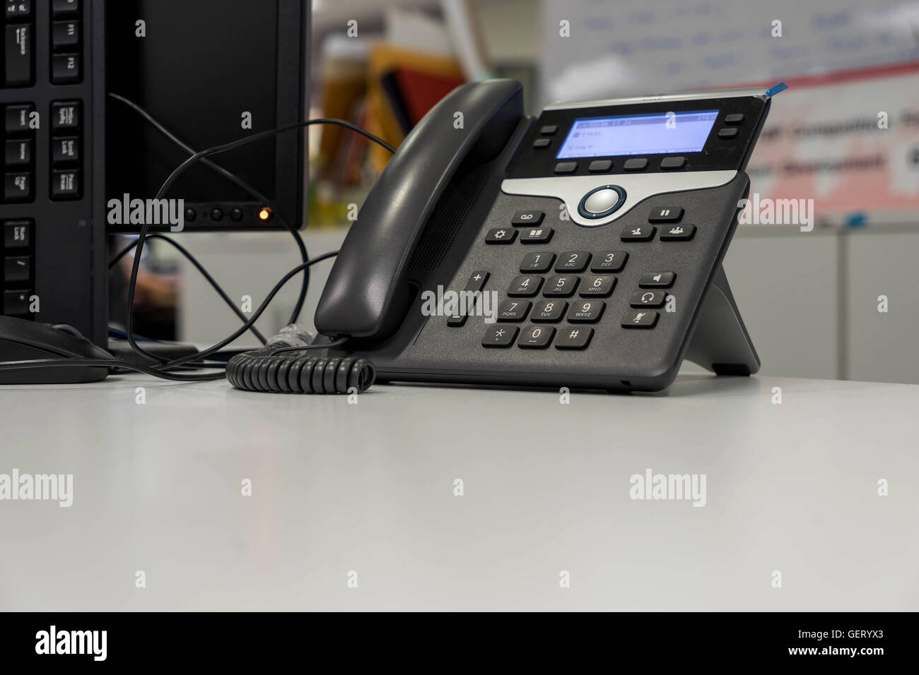 Telefono VOIP su scrivania bianca e vicino mornitor in office Foto Stock