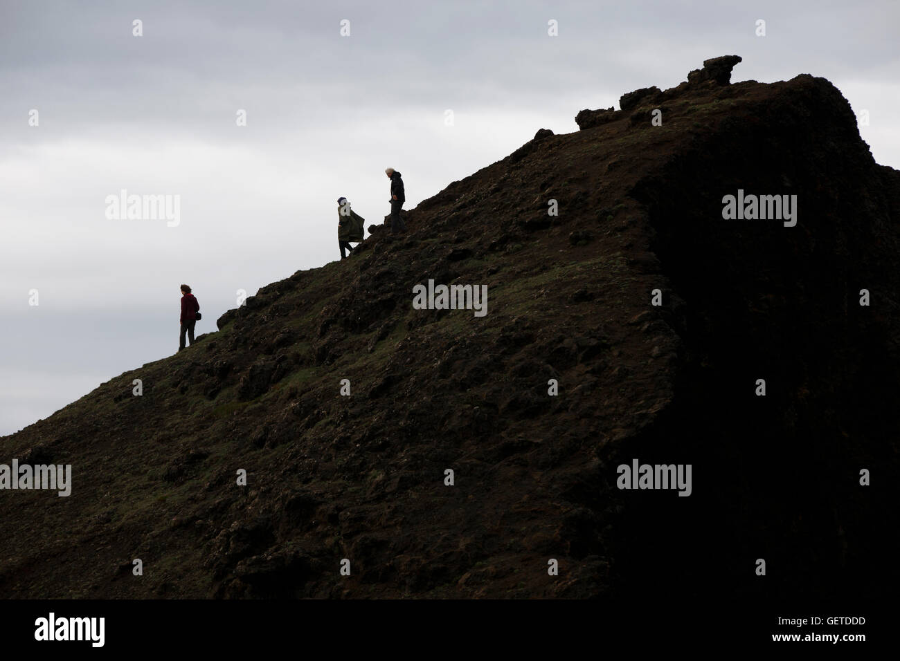 La gente che camminava lungo un costone vulcanico, Hafnaberg, Islanda Foto Stock