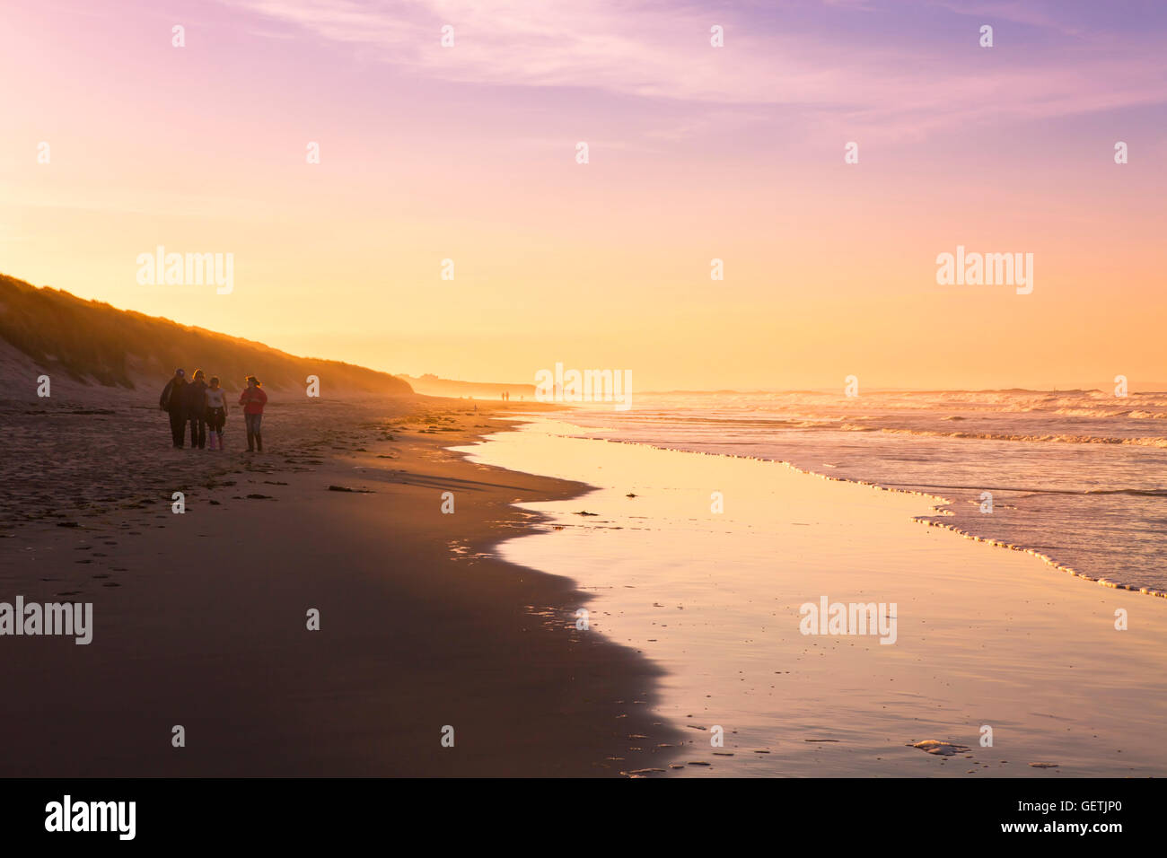 Una famiglia godetevi l'ultimo di un giorno di estate sulla spiaggia. Foto Stock