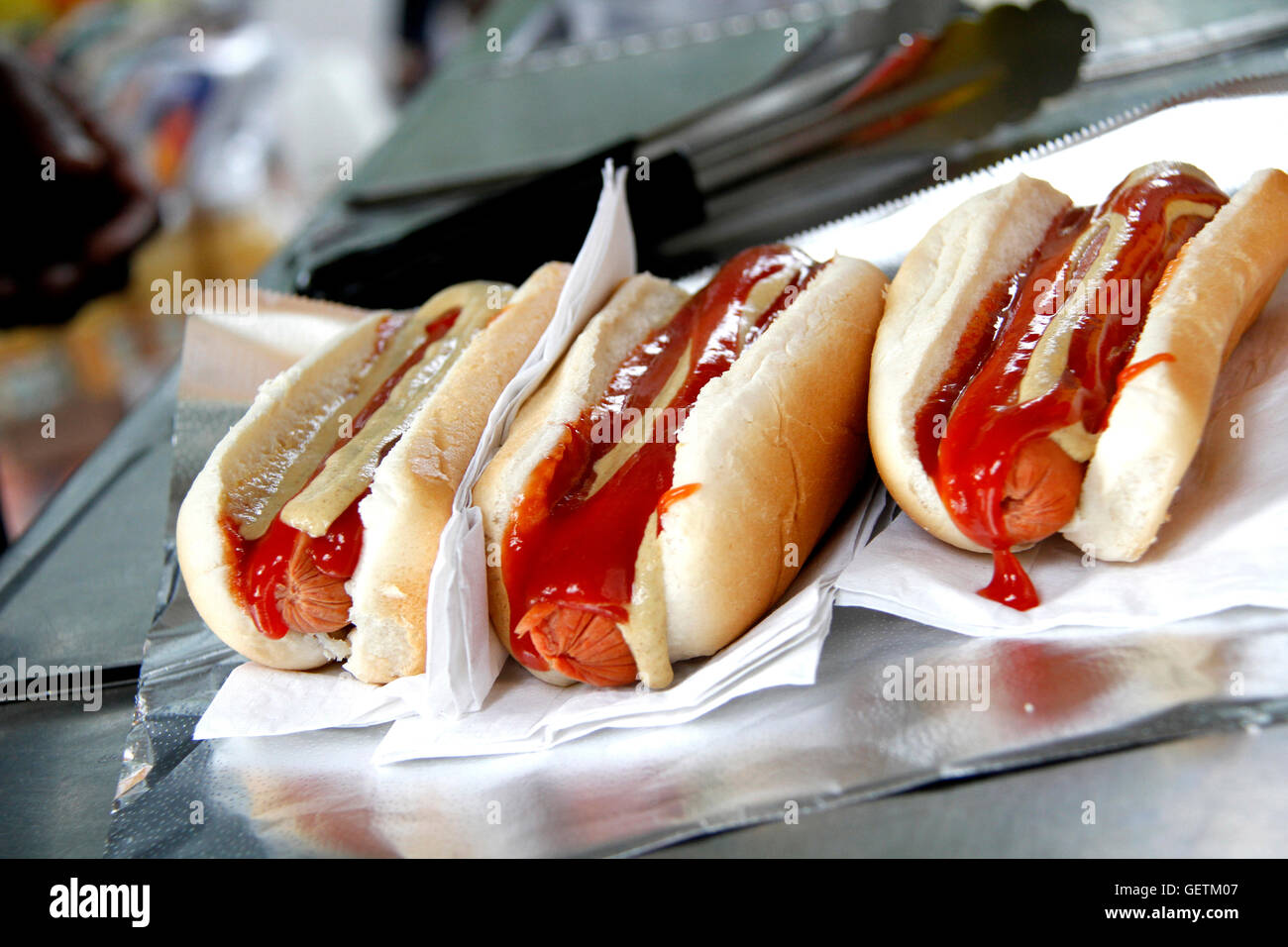 Tre hot dog con ketchup e senape sulle ciambelle. Foto Stock