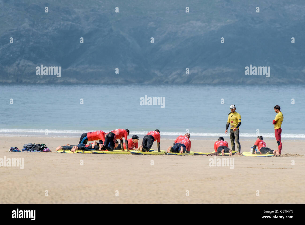 Scuola di Surf istruttori novizi di insegnamento su Fistral a Newquay in Cornovaglia. Foto Stock