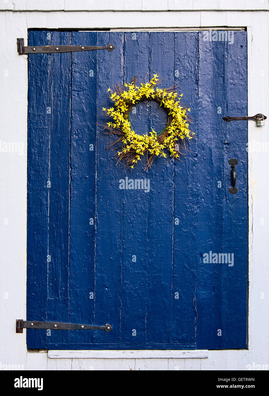 Semplice ghirlanda di fiori su rustiche porta blu. Foto Stock