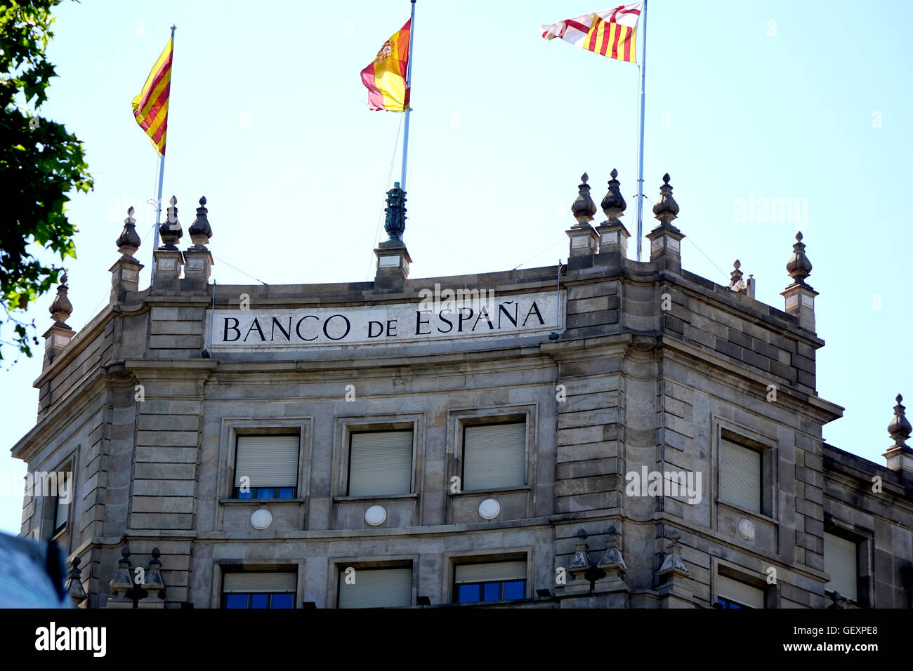 Banco de Espana battenti Spagnolo e Catalano bandiere sulla sommità dell'edificio. Foto Stock