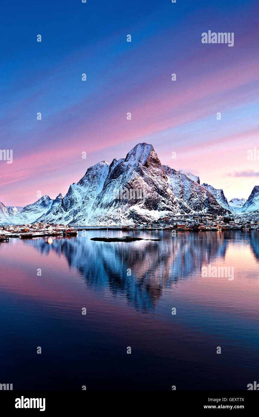 La luce rosa di un inverno alba dietro al Monte Olstind e Reine città. Foto Stock