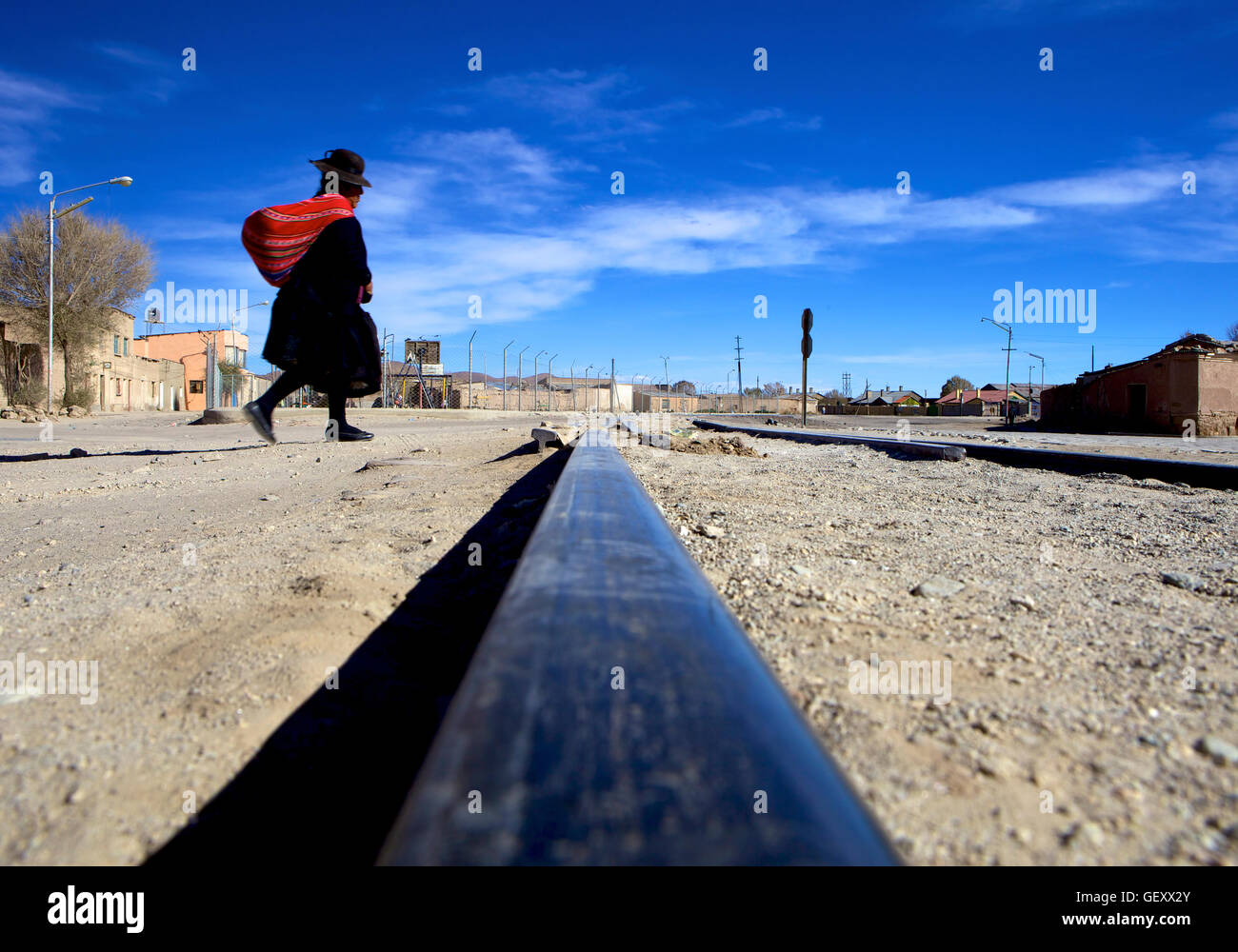 Tradizionalmente condita lady attraversamento binari del treno a Uyuni. Foto Stock