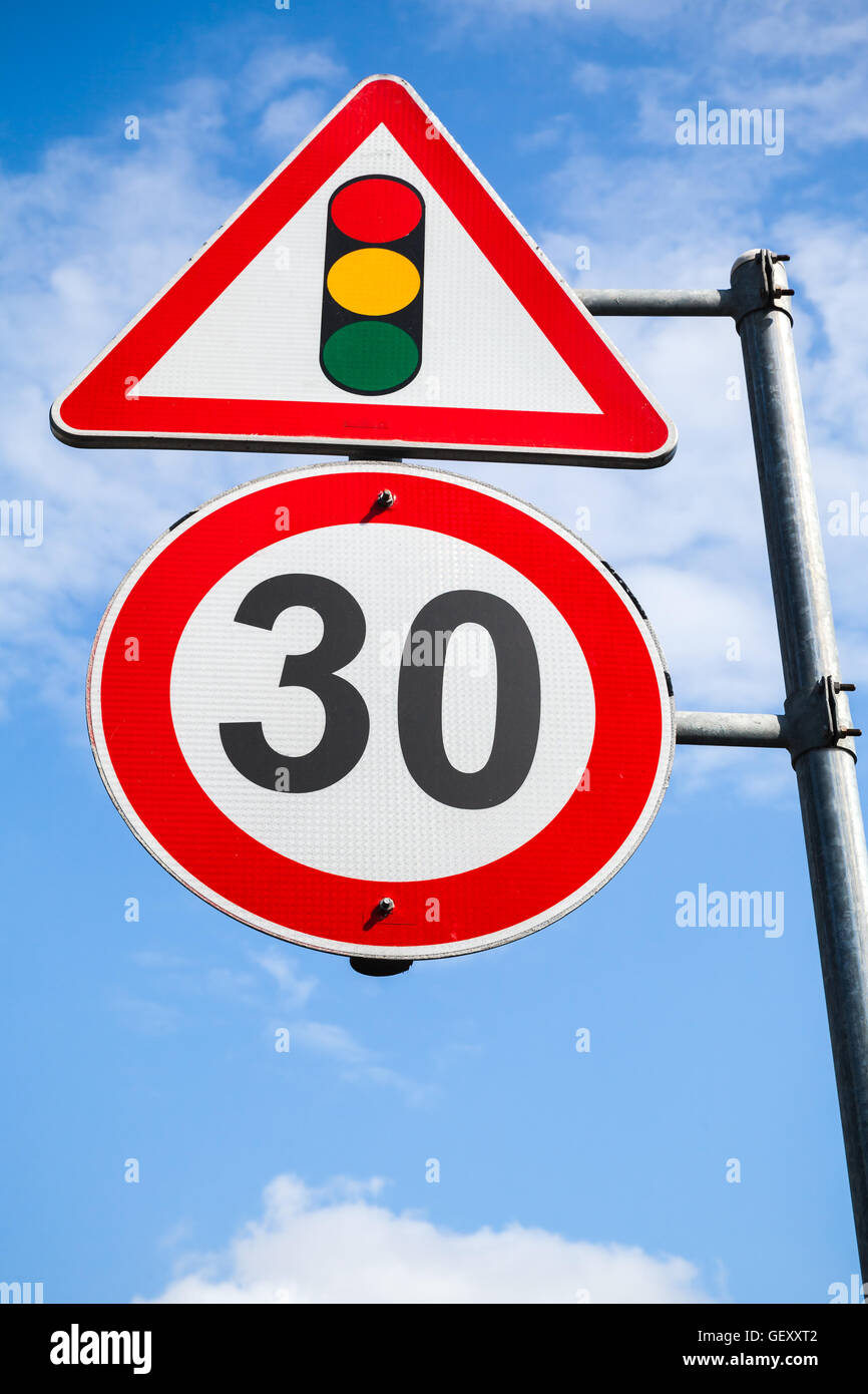 Il semaforo e limite di velocità a 30 km all'ora sono su un montante  metallico. Segnaletica stradale oltre il cielo blu sullo sfondo Foto stock  - Alamy