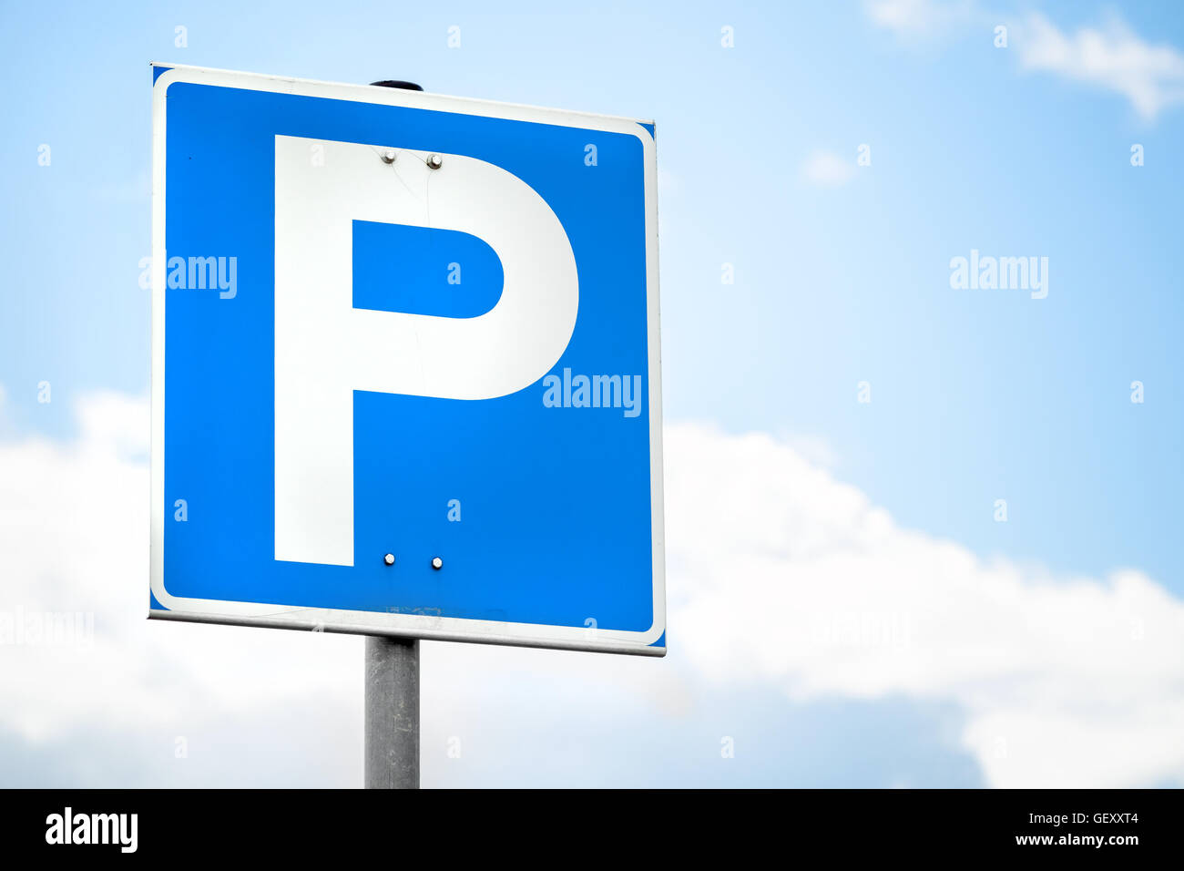 Blue square parcheggio cartello stradale oltre il cielo luminoso sullo sfondo Foto Stock
