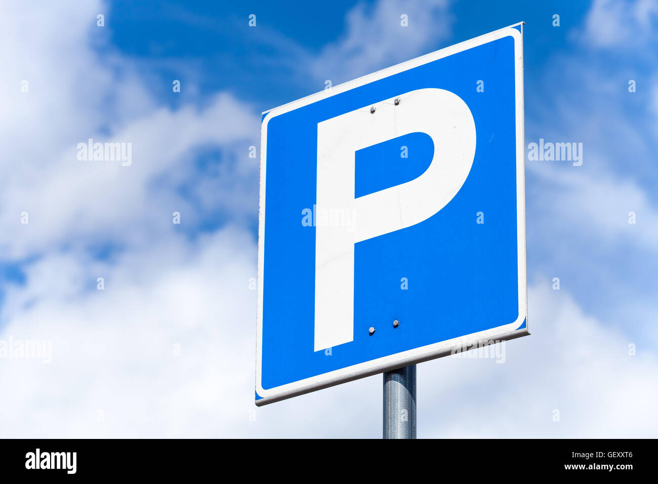 Blue square parcheggio cartello stradale su sfondo con cielo nuvoloso Foto Stock