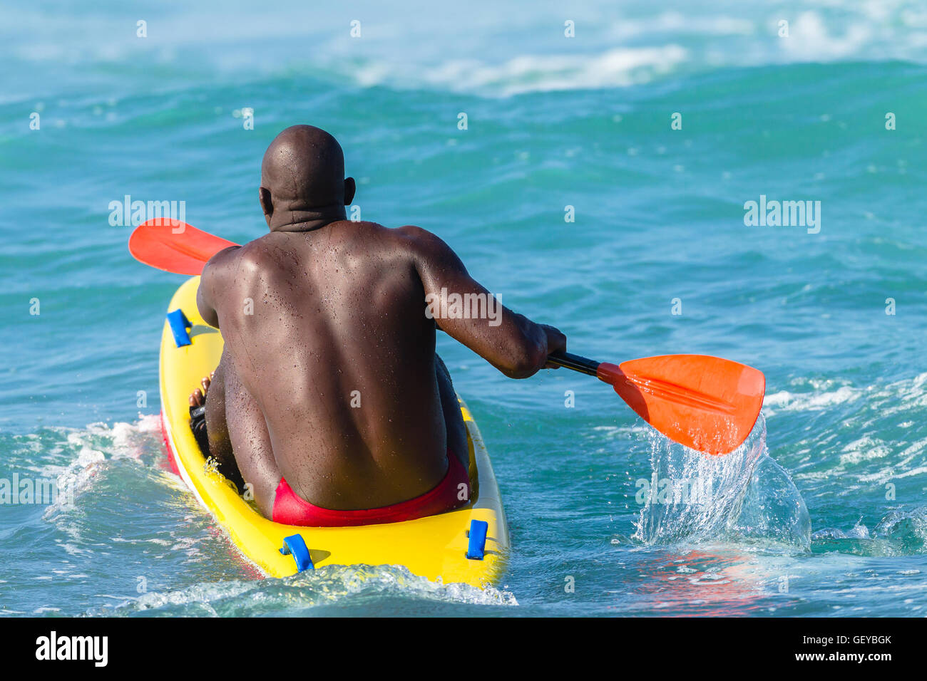 Bagnino paddling giallo rosso mezzo di salvataggio oceano onde Foto Stock