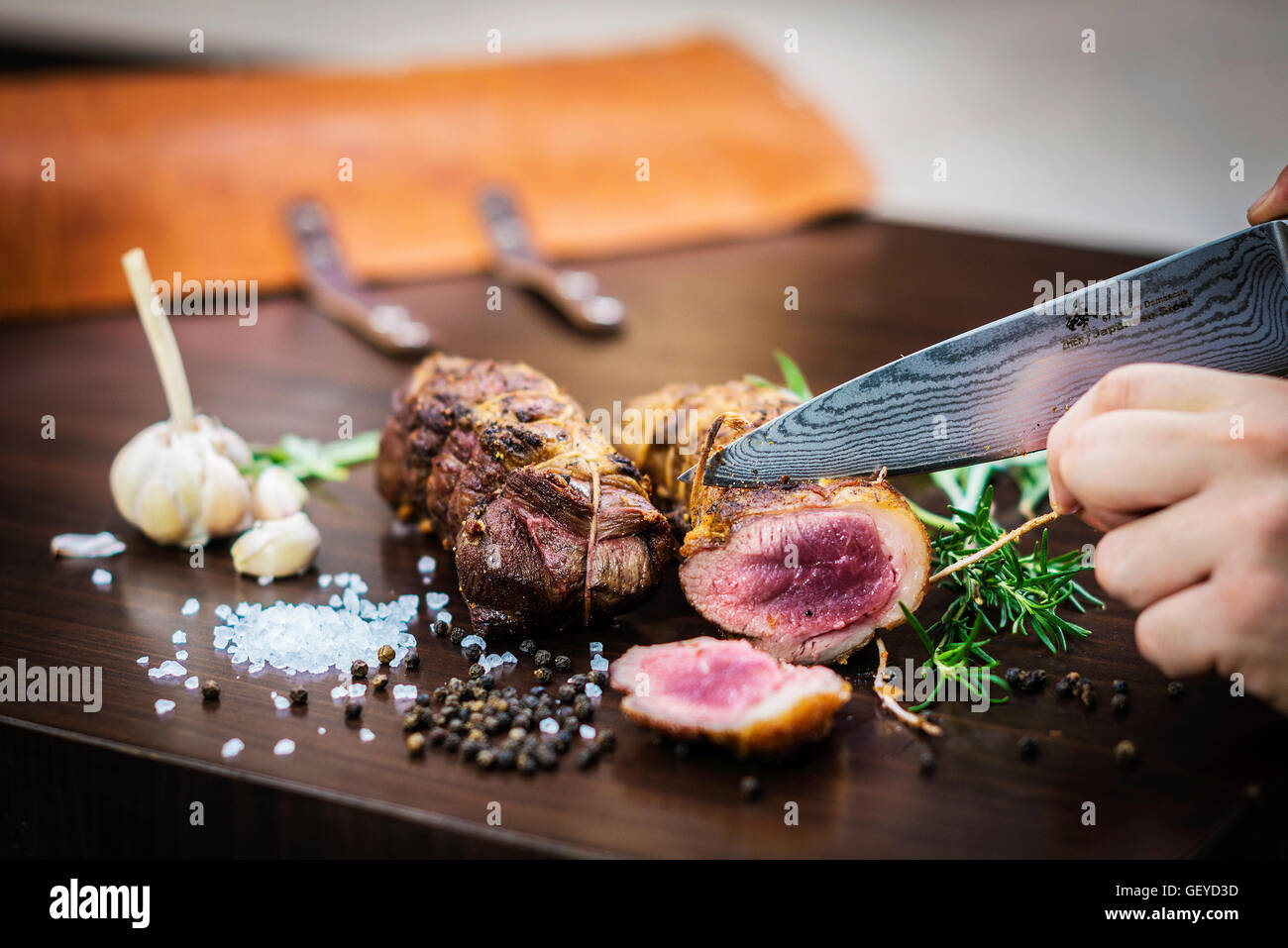 Servire il carving arrosto di maiale rotolo di carne pasto in stile rustico con condimenti Foto Stock