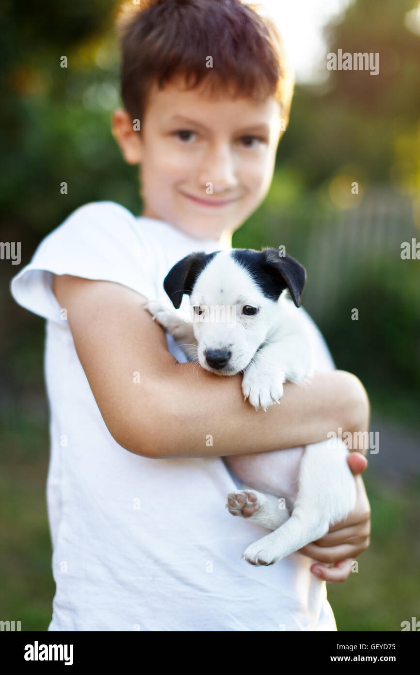 Happy little boy holding jack russell terrier kid outdoor Foto Stock