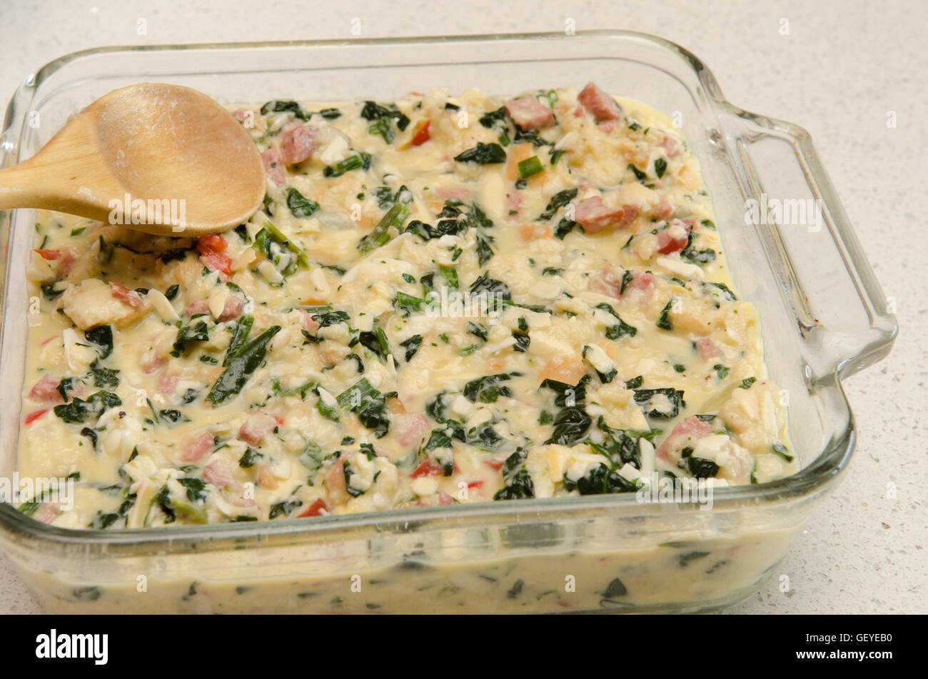 Materie casseruola di uovo, gli spinaci e le salsicce in una teglia prima della cottura Foto Stock