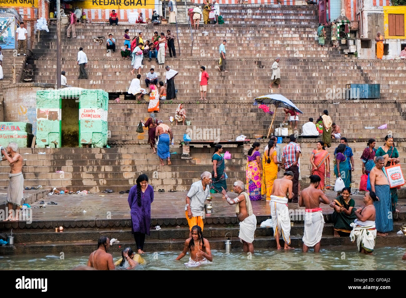 Una folla di persone che compiono il loro mattina rituale di purificazione sul ghats del Fiume Gange, Varanasi, Uttar Pradesh, India Foto Stock