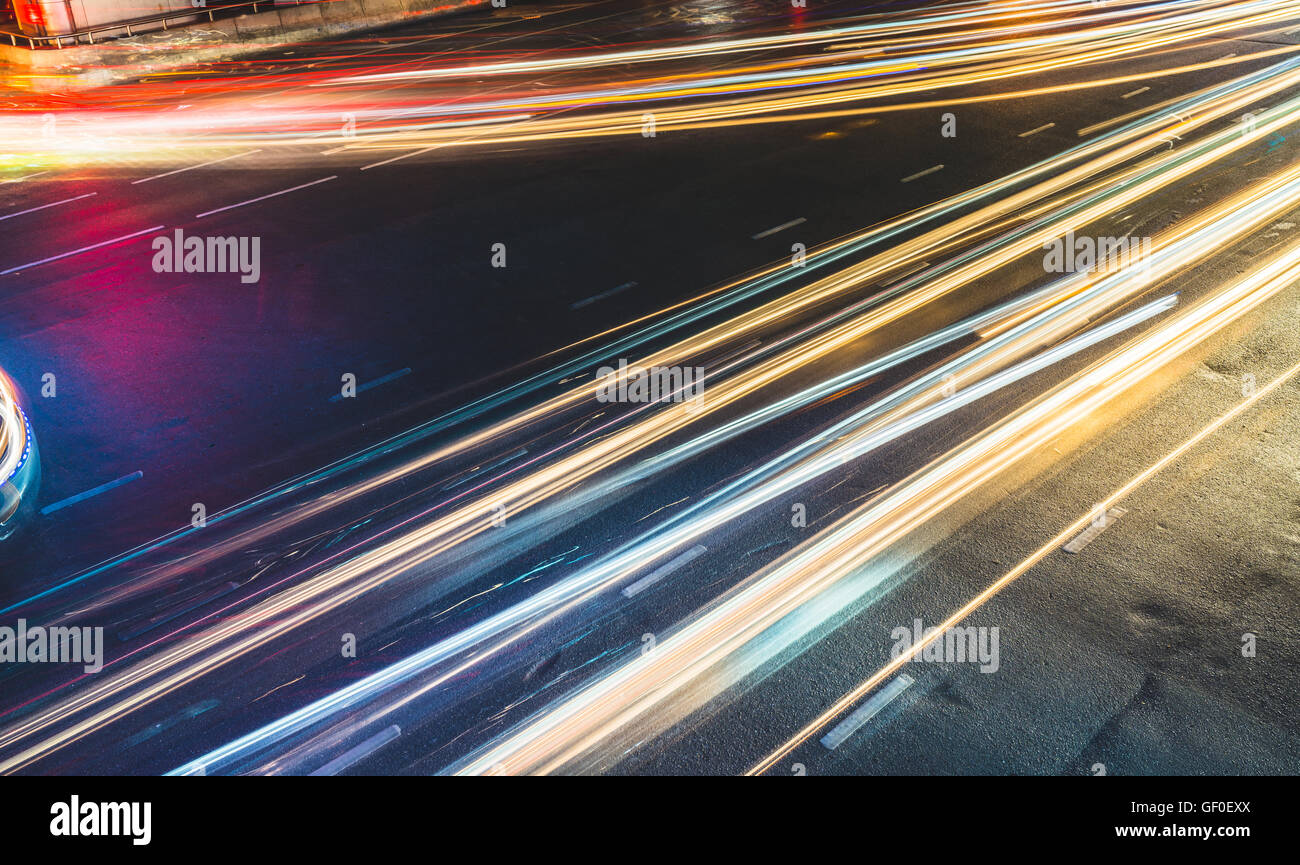 Colorata esposizione lungo sentieri di luce attraverso nodo stradale, traffico o concetto astratto di velocità Foto Stock