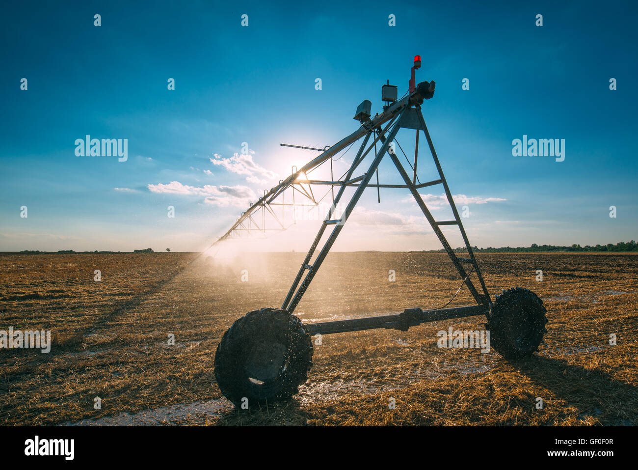 Agricola automatizzata del perno centrale del sistema di irrigazione a goccia sprinkler nel raccolto frumento campo di stoppie in tarda estate dopo Foto Stock