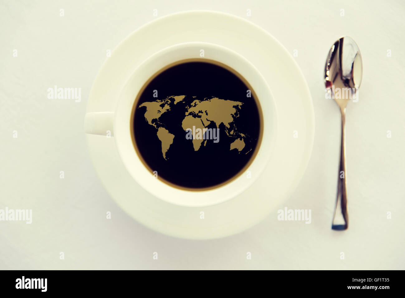 Mappa del mondo in tazza di caffè nero con il cucchiaio Foto Stock