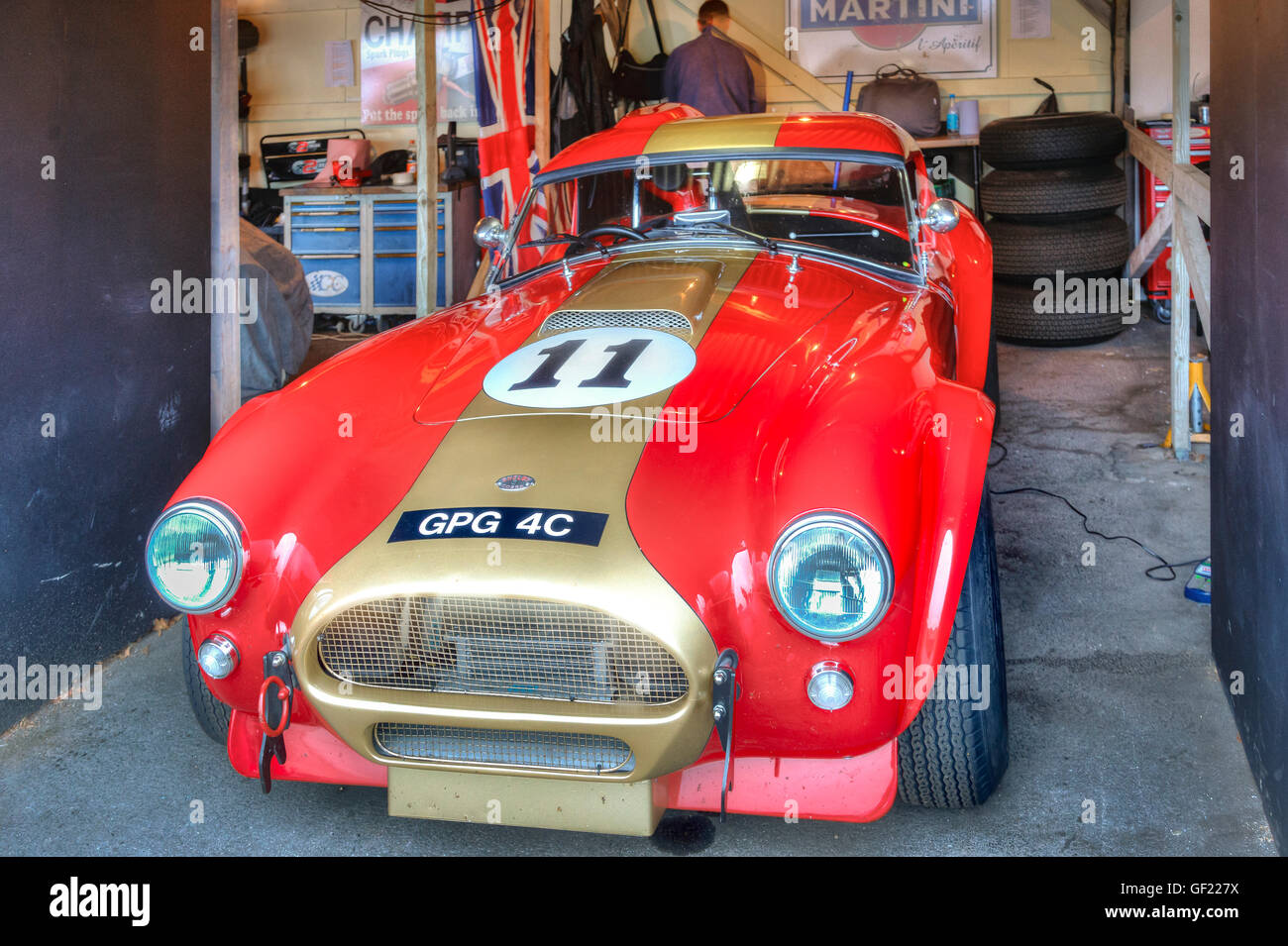 1964 AC Cobra nel paddock garage preparato per il RAC celebrazione TT race, 2015 Goodwood, Sussex, Regno Unito. Foto Stock