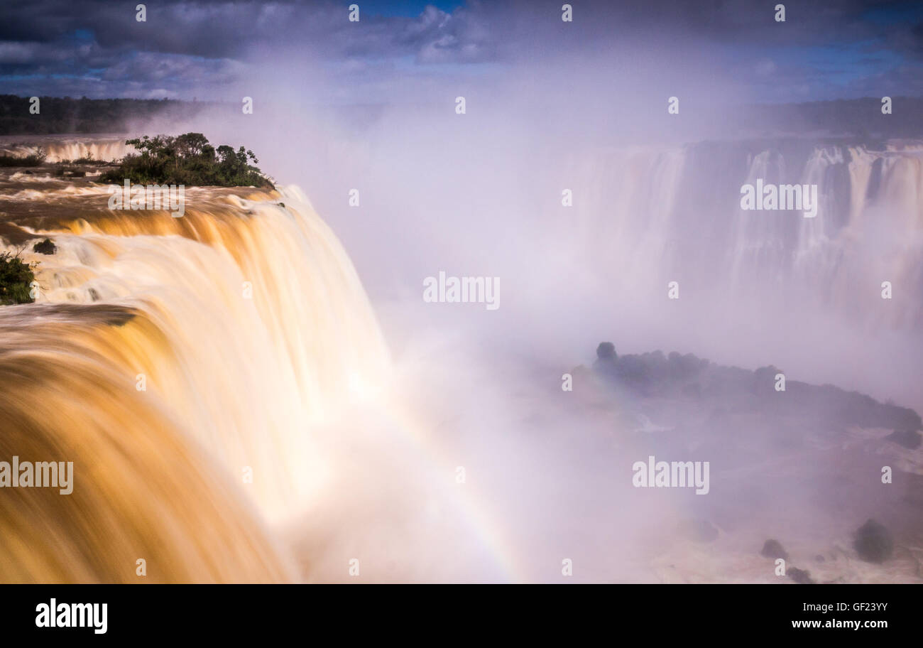 Un arcobaleno forme sopra le cascate Iguacu gigante come quantità di acqua caduta giù il 82m alto cade Foto Stock
