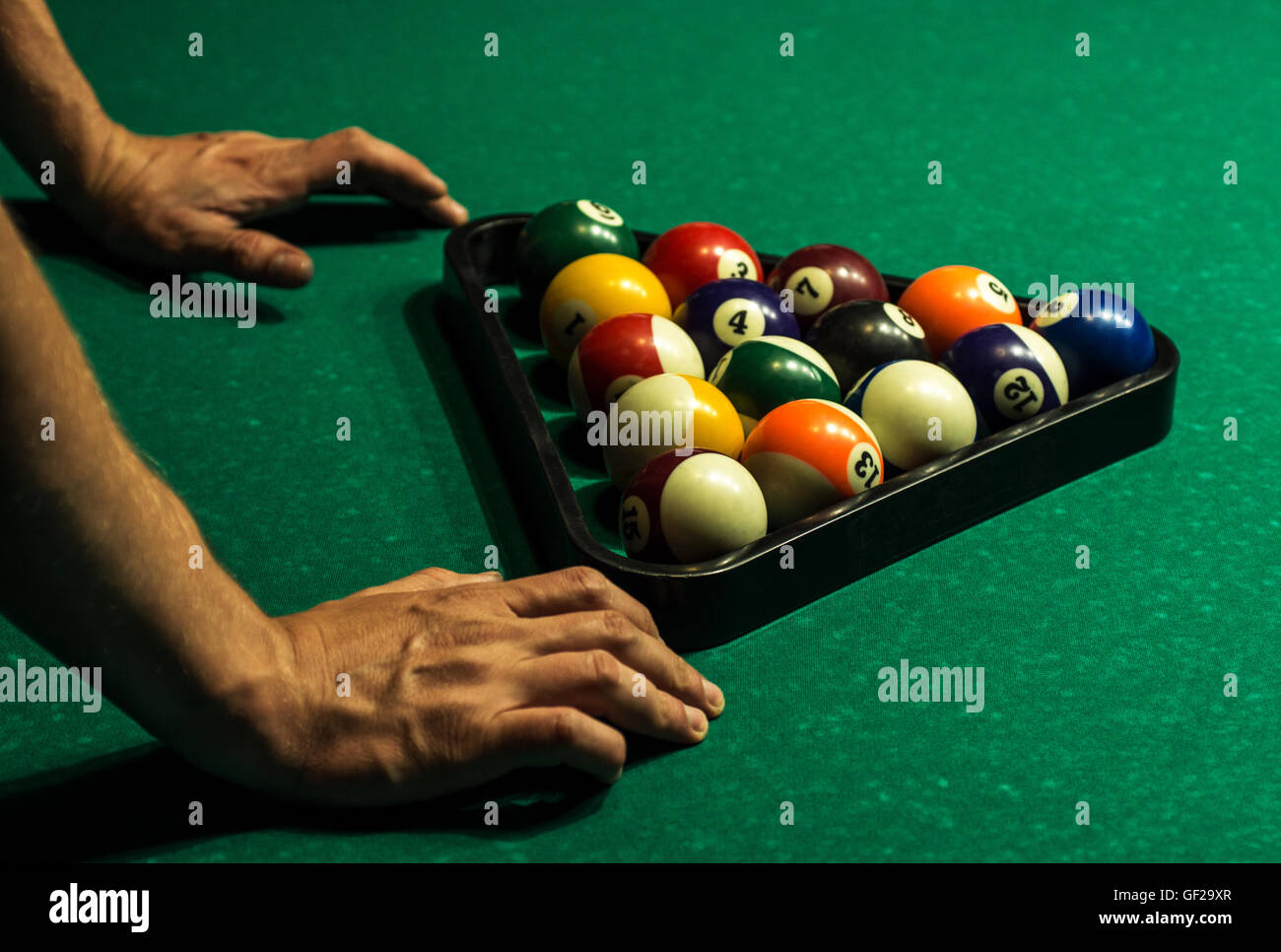 Un pool player getting palle nel triangolo pronto per un gioco Foto Stock