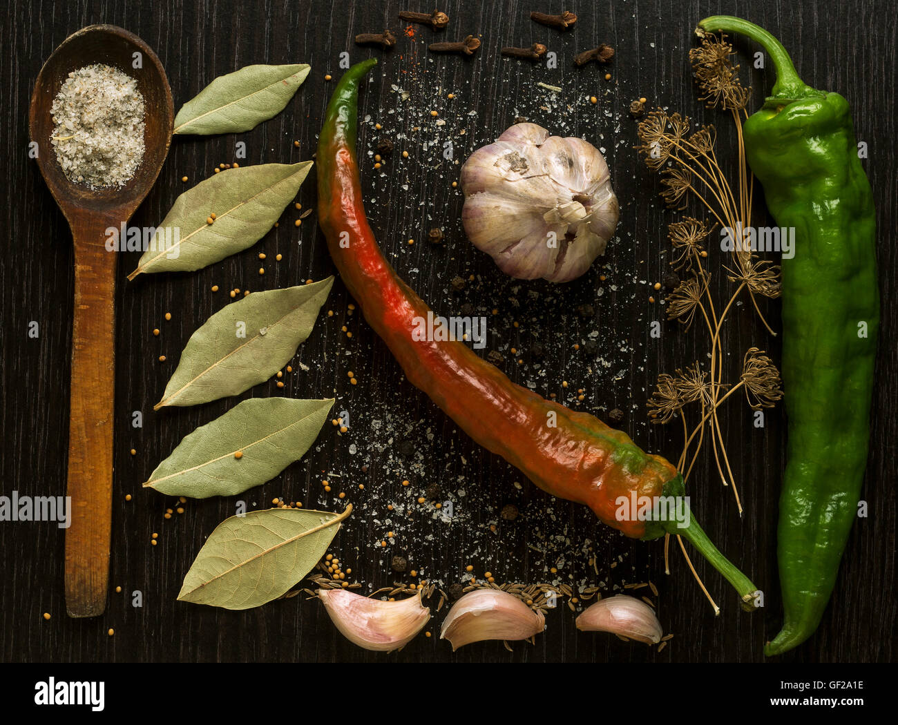 Un insieme di erbe e spezie su di un legno nero tavolo da cucina Foto Stock