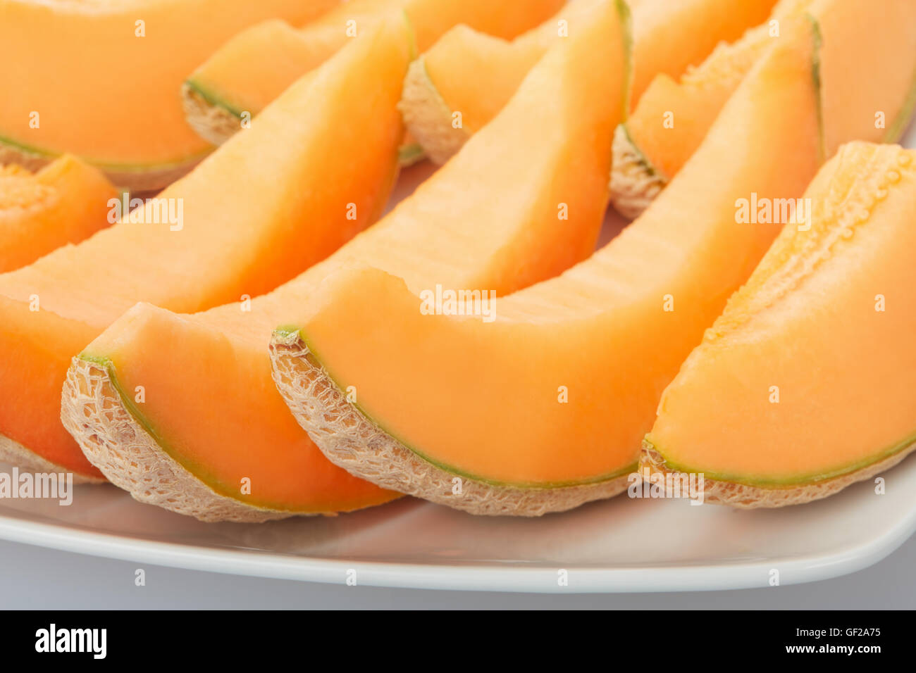 Il melone Cantalupo, fettine di arancia sul piatto Foto Stock