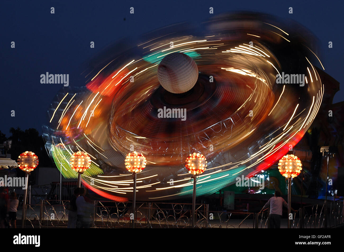 Illuminata Merry Go Round di sera, le luci disegna percorsi. Foto Stock