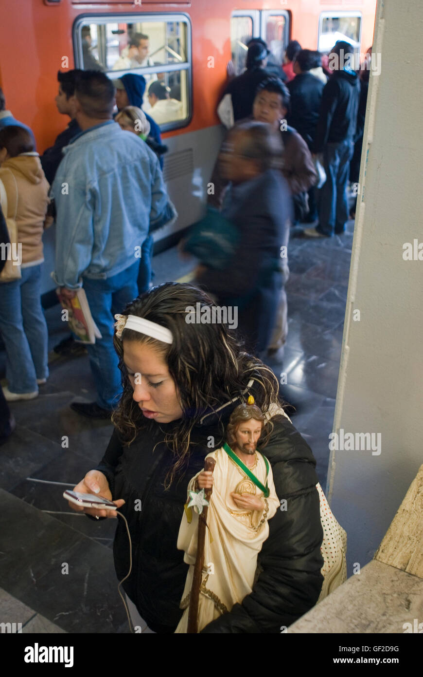 Una giovane donna, con la statua di San Giuda Taddeo, patrono delle cause perse, attende a bordo della Città del Messico alla metropolitana Foto Stock