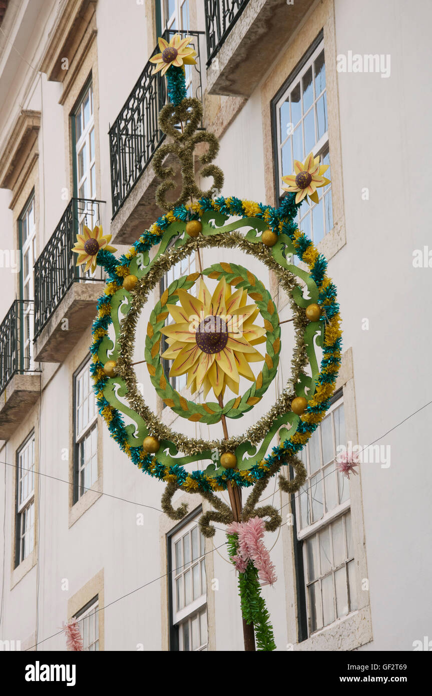 Un girasole motivo al centro di una Pasqua decorazione fatta di tinsel, sospese al di sopra di un vicolo in Alfama, Lisbona, Portogallo. Foto Stock