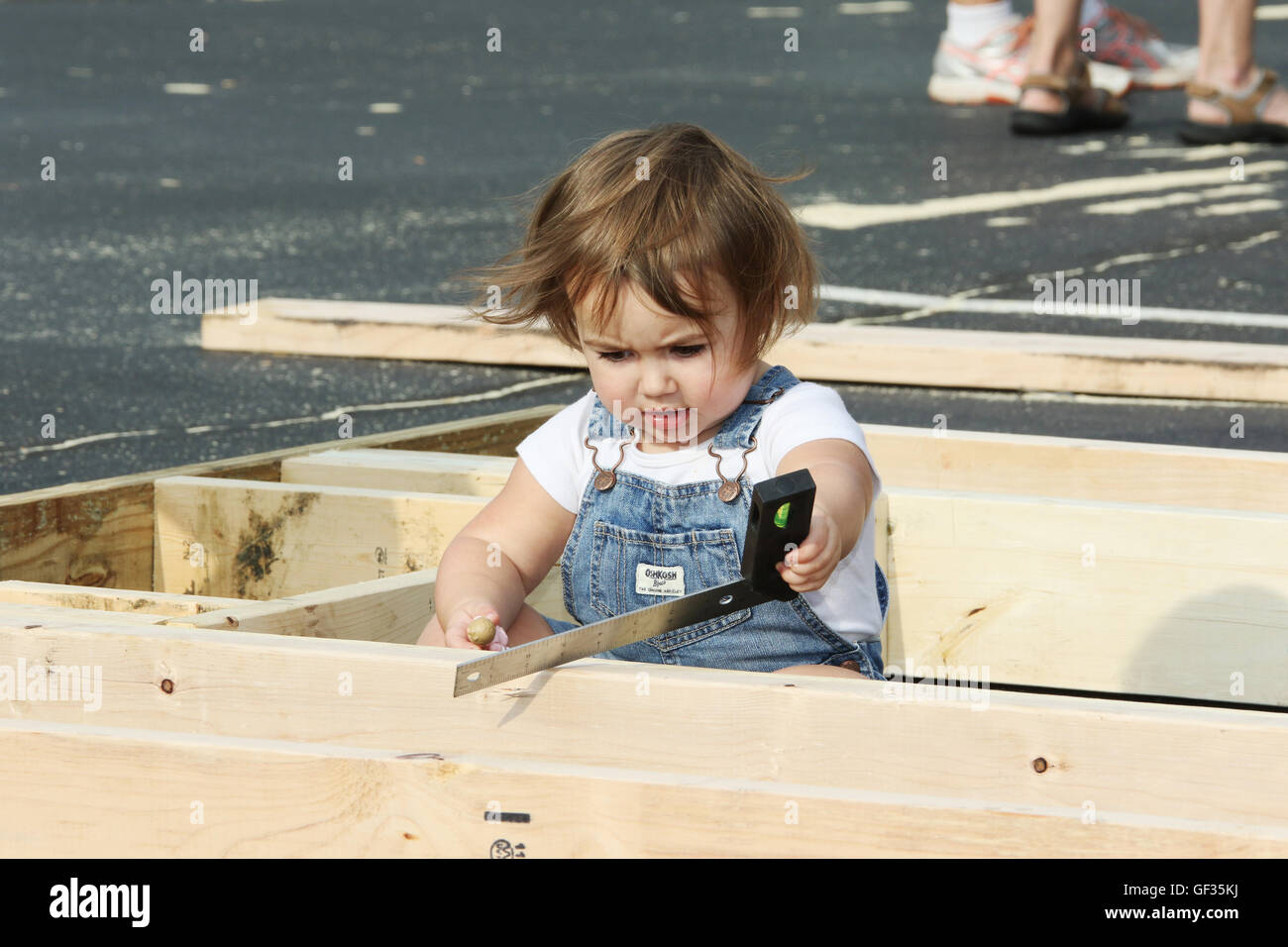Il Toddler volontario di costruzione di una parete. Habitat for Humanity parcheggio costruire. La costruzione di sezioni della casa a Beavercreek chiesa del Foto Stock
