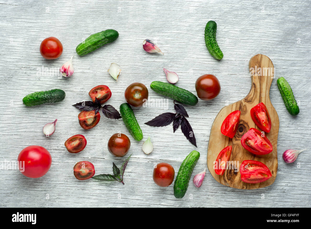 Pomodori con basilico sul tavolo di legno dello sfondo. Composizione alimentare. Vista superiore Foto Stock