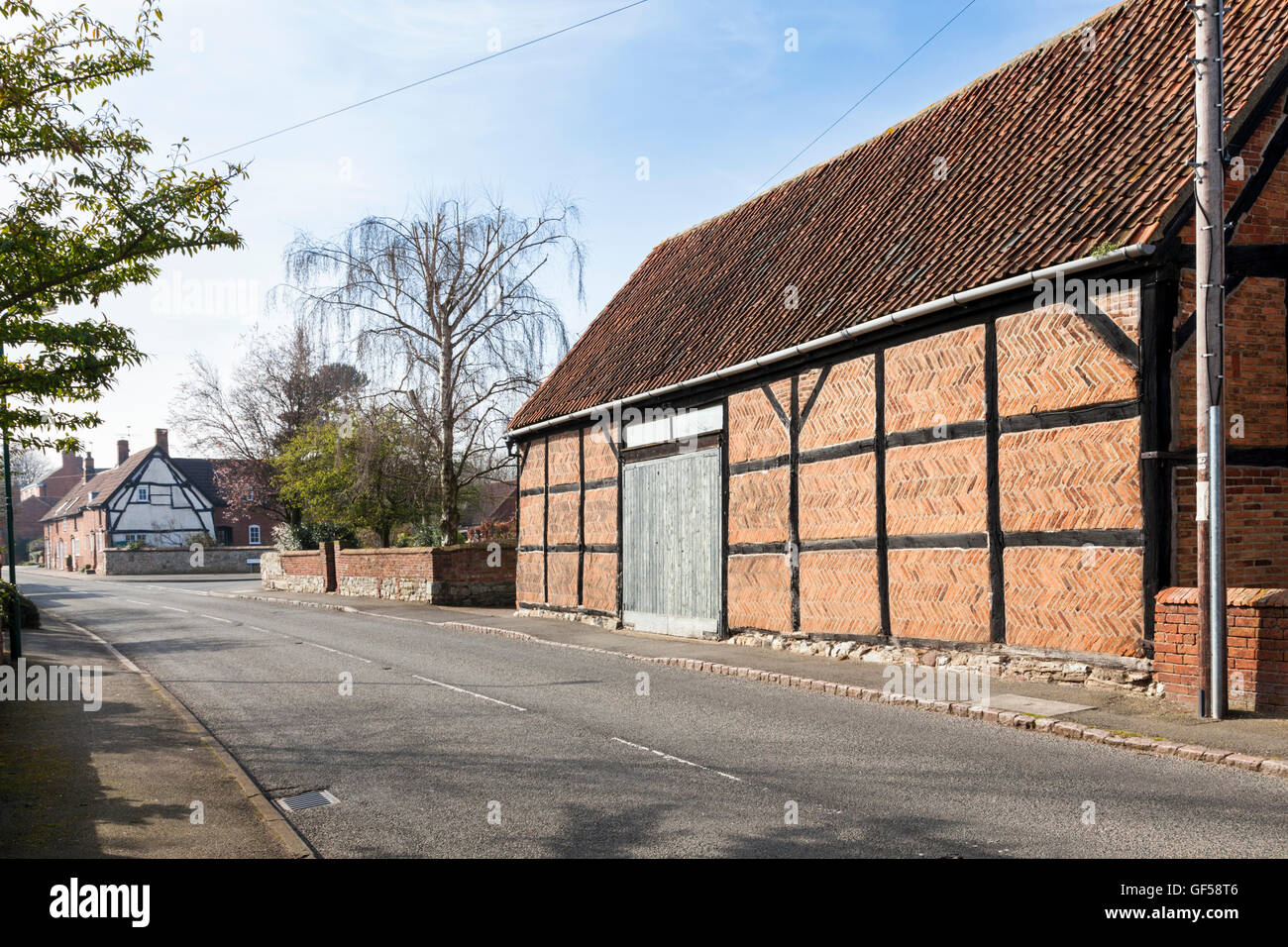 Vecchio legno incorniciata edificio con muratura in mattoni a spina di pesce nel villaggio di Hoton, Leicestershire, England, Regno Unito Foto Stock