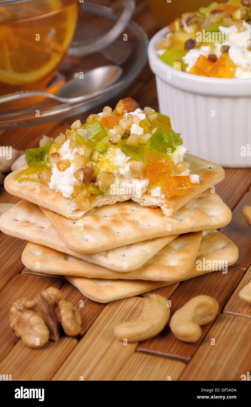 Porzione di formaggio con marmellate e confetture, dadi su un cracker Foto Stock