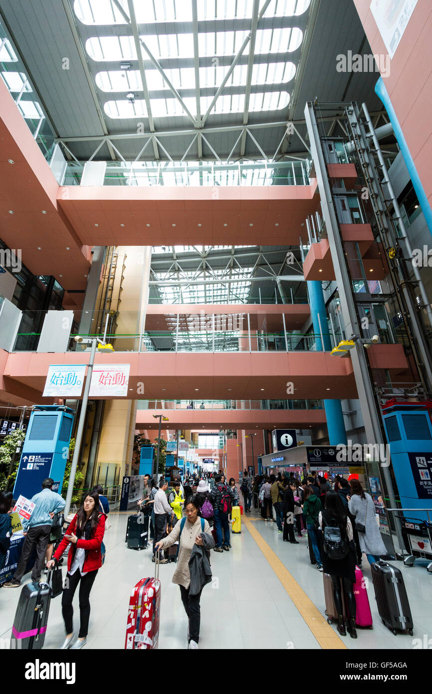 Aeroporto Kansai, Giappone. Interno, terminale 1. Vista generale lungo l'interno con la gente, pareti interne di partenza piani e passerelle di collegamento. Foto Stock