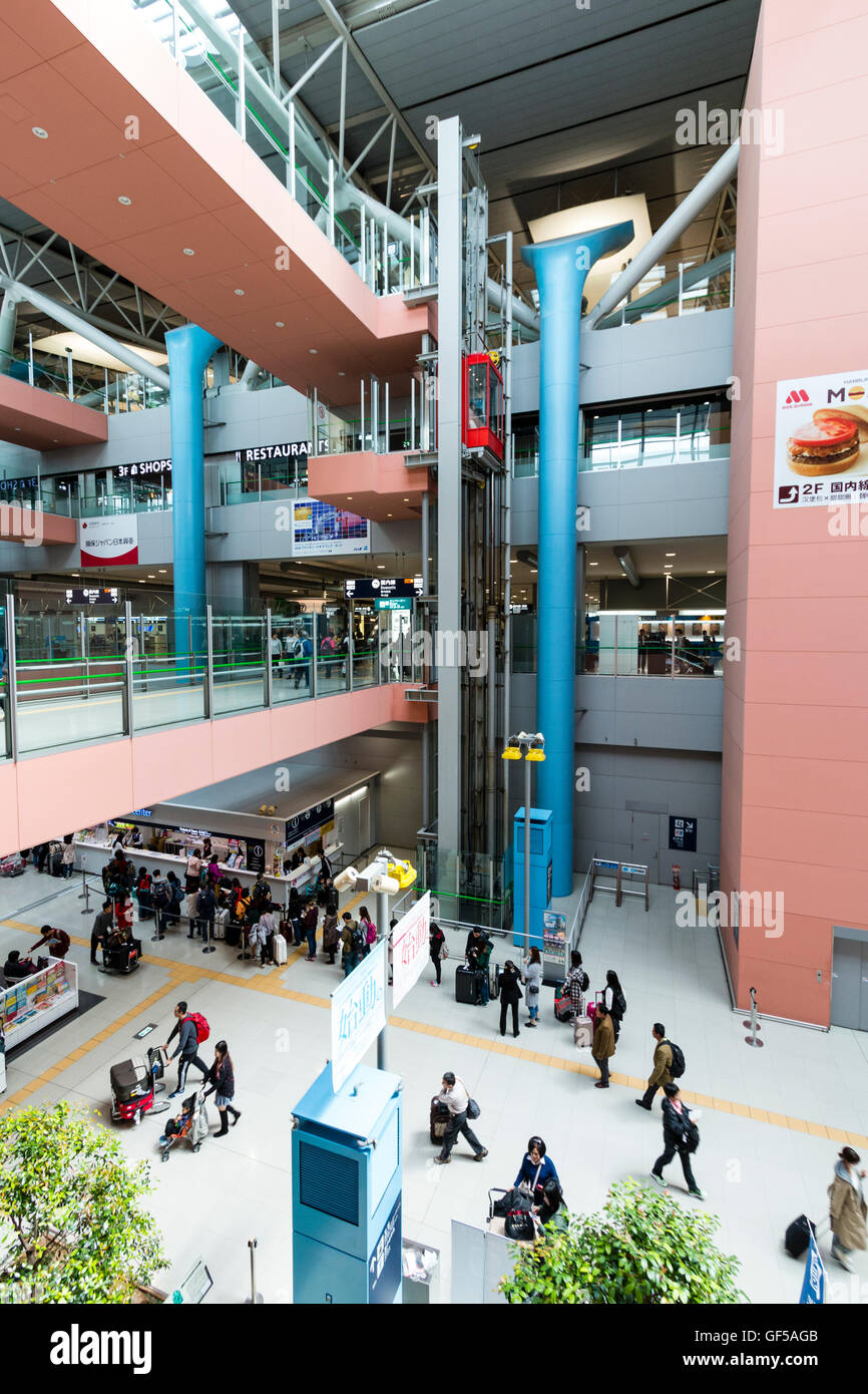Aeroporto Kansai, Giappone. Interno, terminale 1. Vista generale lungo l'interno con la gente, pareti interne di partenza piani e passerelle di collegamento. Foto Stock