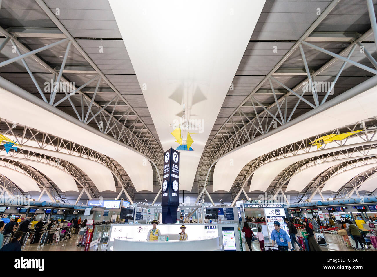 Giappone, Kansai, Aeroporto KIX. Interno di un terminale. International check-in. Informazioni presidiato contatore nel centro, banchi check-in su entrambi i lati. Foto Stock