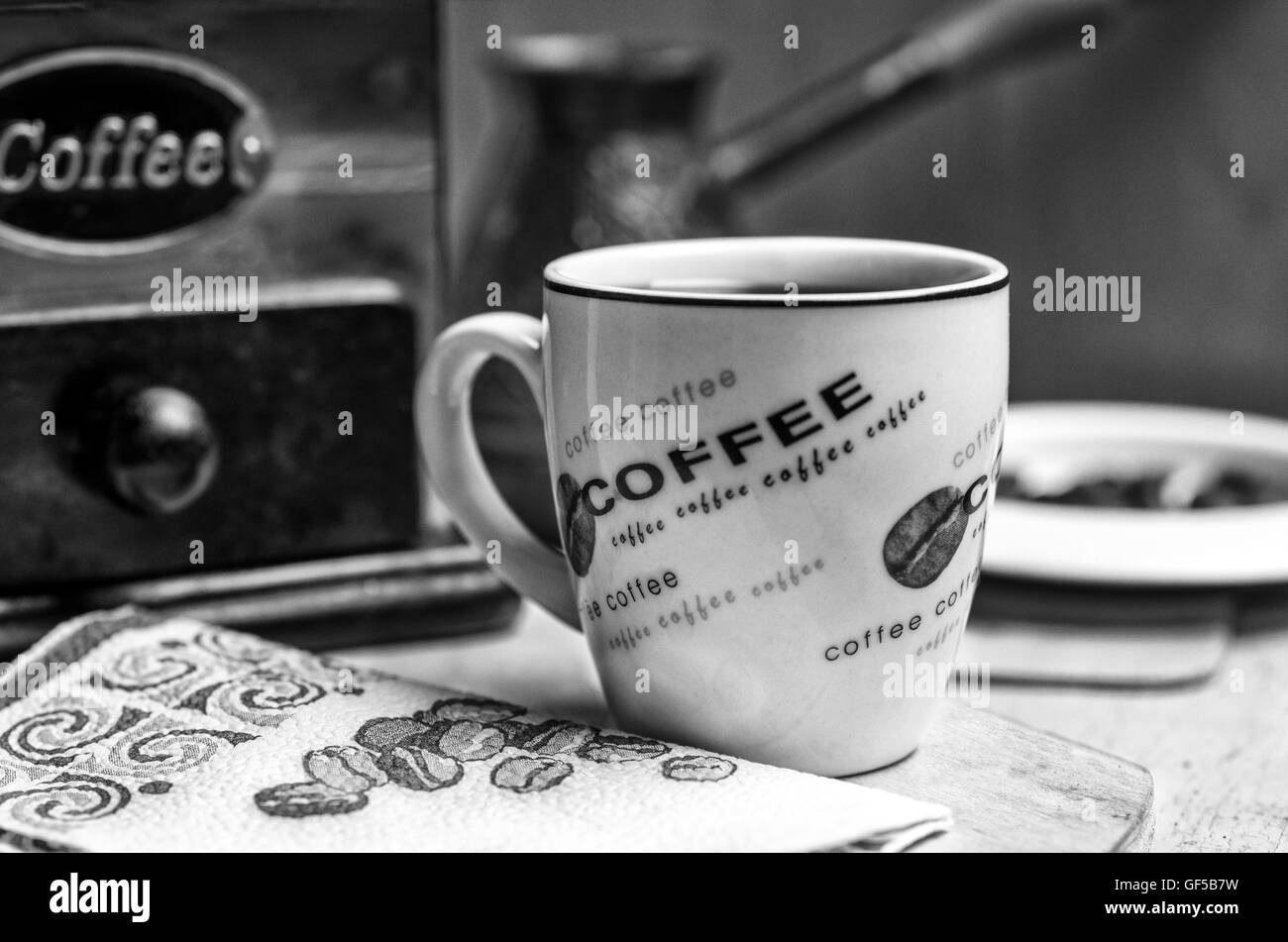 Una tazza di caffè con una smerigliatrice girato in bianco e nero Foto Stock