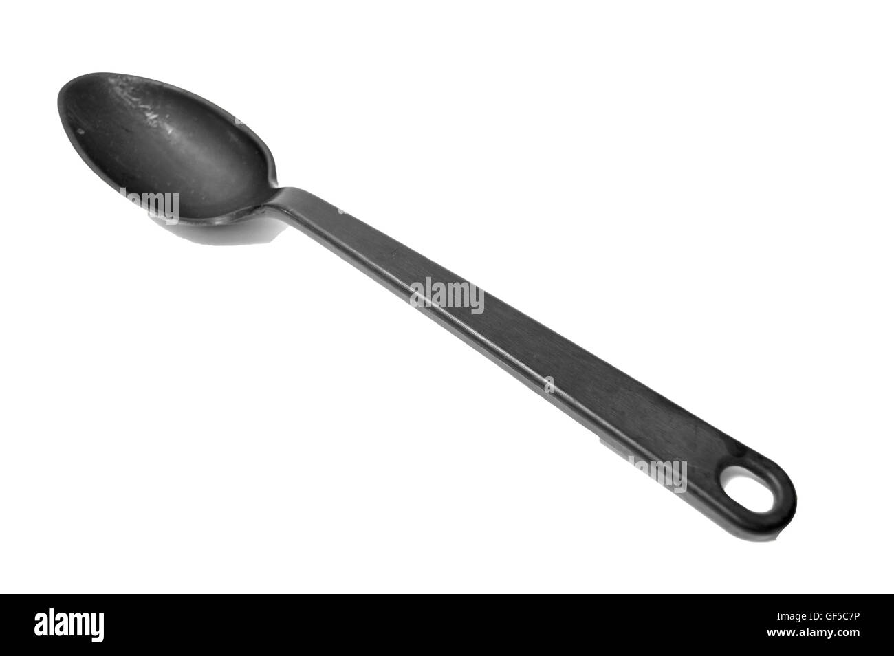 Una plastica nera cucchiaio su uno sfondo bianco. Foto Stock