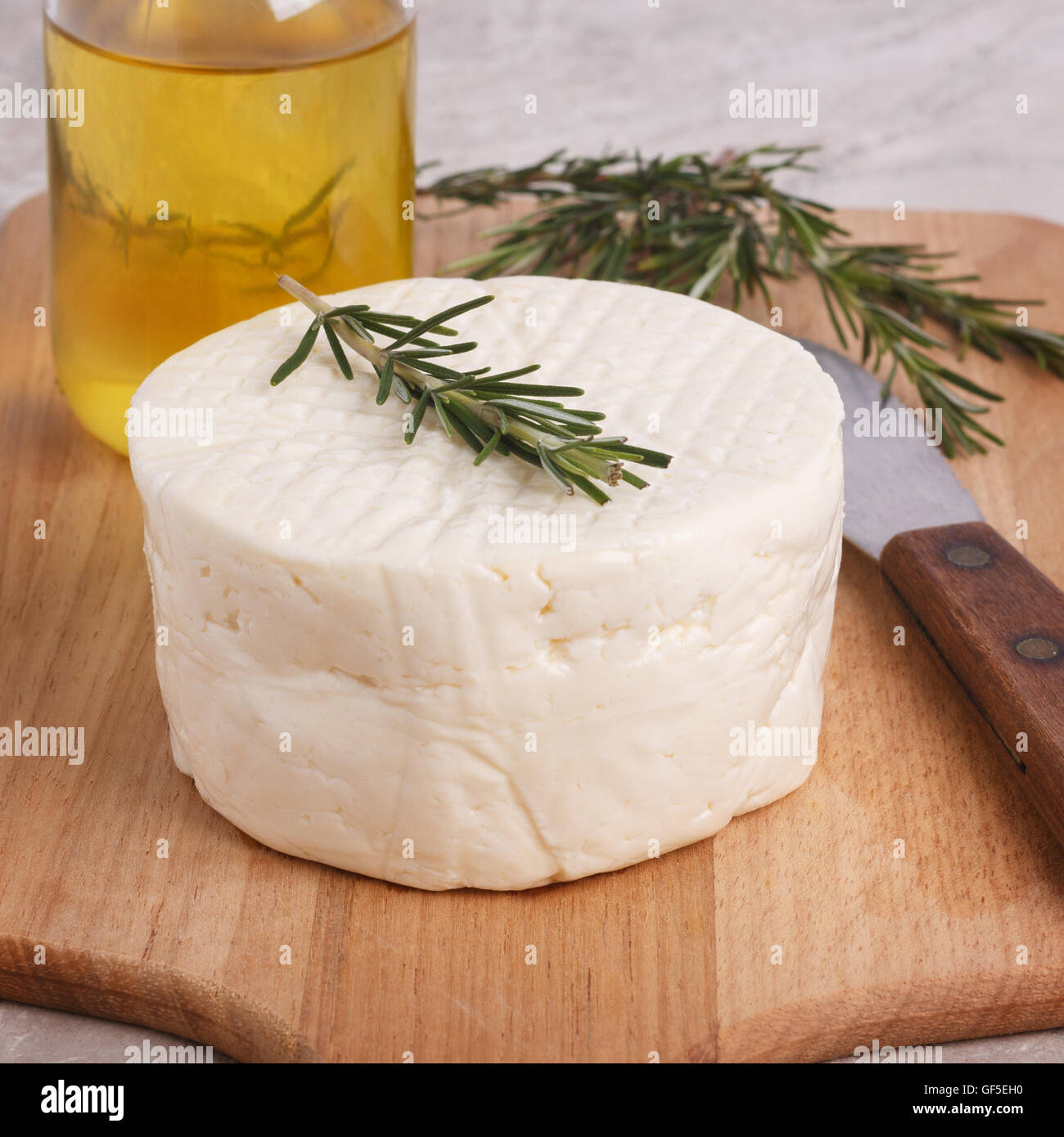 Ruota del brasiliano formaggio tradizionale Minas su tavola di legno con olio di oliva. Messa a fuoco selettiva Foto Stock