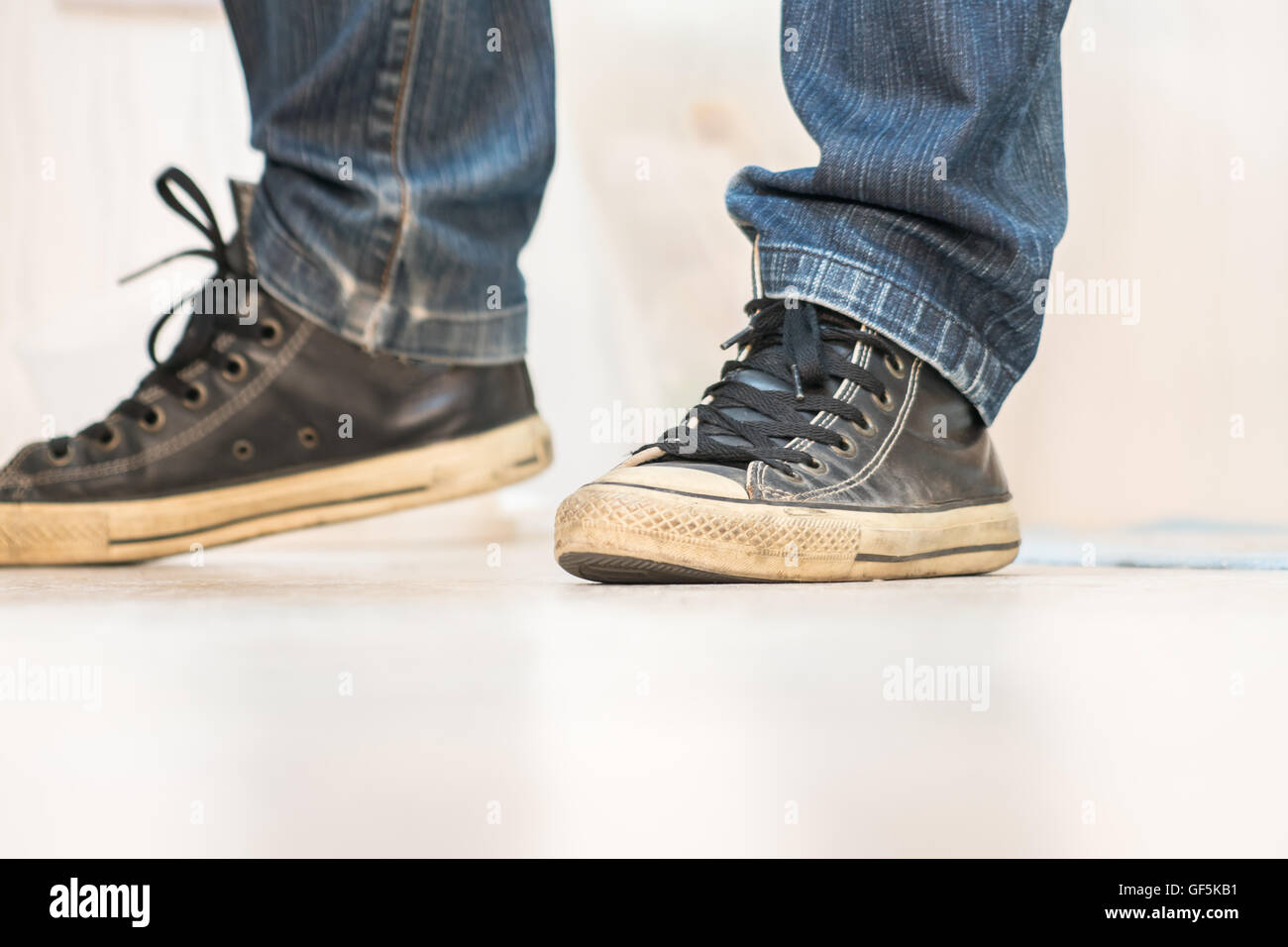 Una coppia di vintage cercando, scarpe da ginnastica e skinny jeans Foto Stock