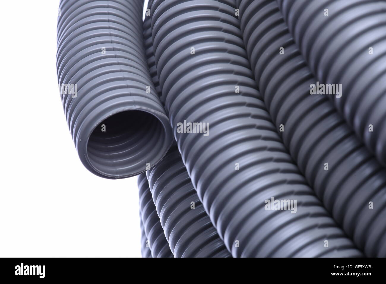 Tubo corrugato per l'installazione di cavo elettrico isolato su sfondo bianco Foto Stock