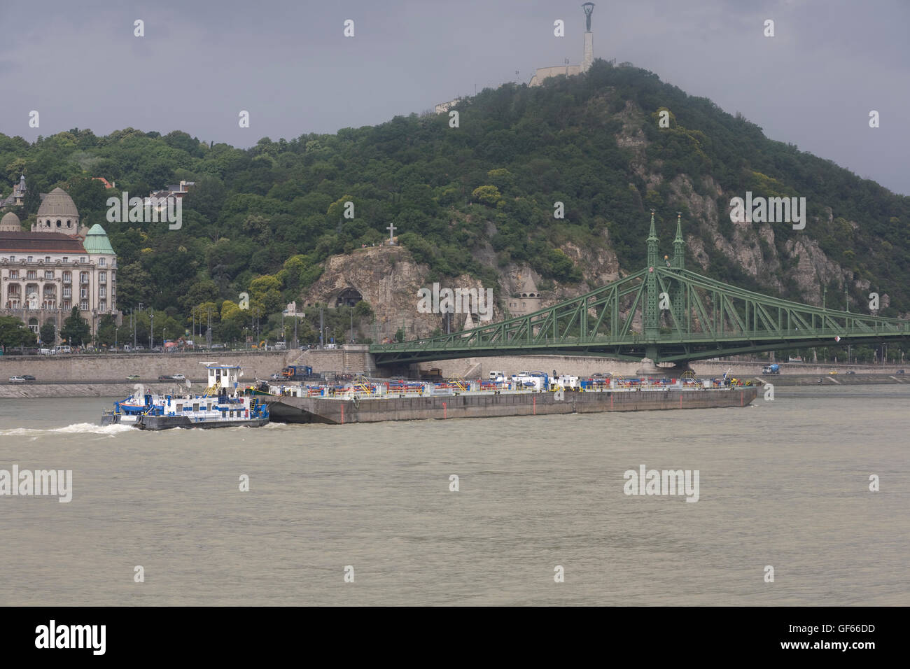 Rimorchiatore spinge barge sotto il ponte Elisabetta sul fiume Danubio con Citadel in background Foto Stock