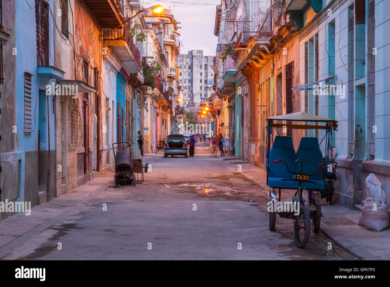 Un risciò ciclo su una strada nel Centro Habana al crepuscolo. L'Avana, Cuba. Foto Stock