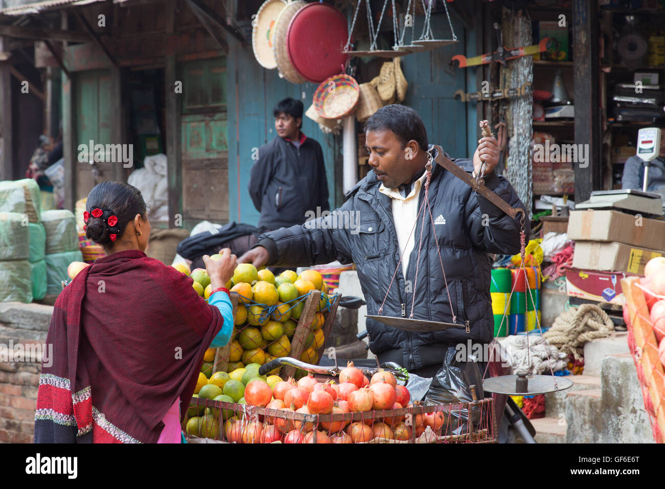 Bhaktapur, Nepal - 5 Dicembre 2014: Frutta venditore con un cliente per le strade. Foto Stock