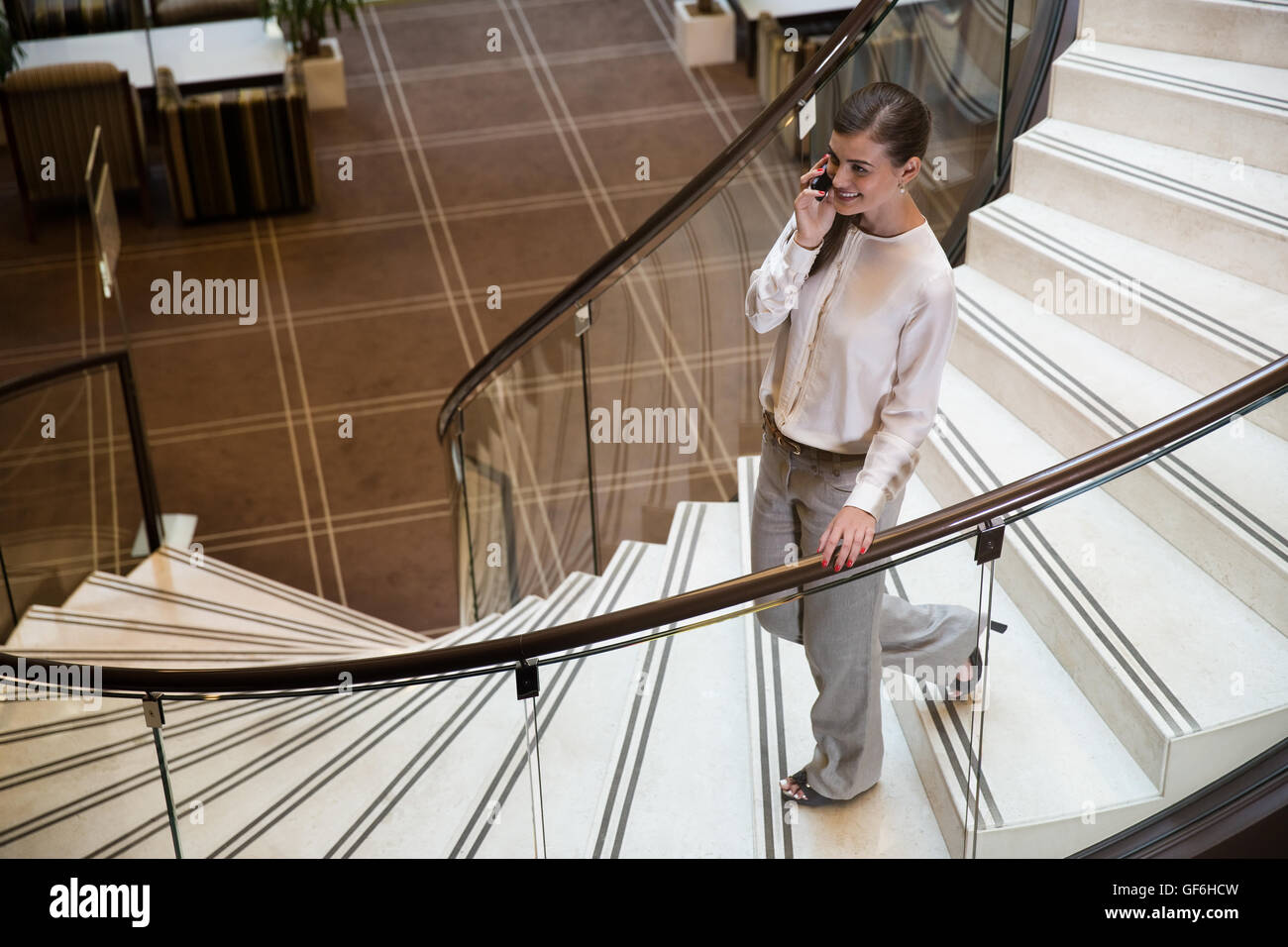 Imprenditrice parlando di telefonia mobile in hotel. Foto Stock