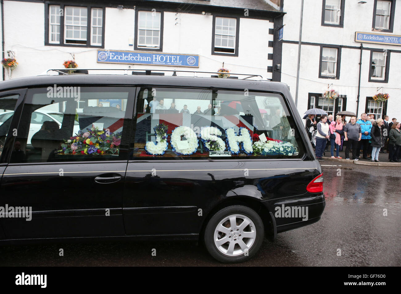 La folla lungo le strade come il trasporto funebre il corpo del caporale Josh Hoole passa attraverso la sua casa di città di Ecclefechan, vicino a Lockerbie in Scozia prima del suo funerale in Dumfries. Foto Stock