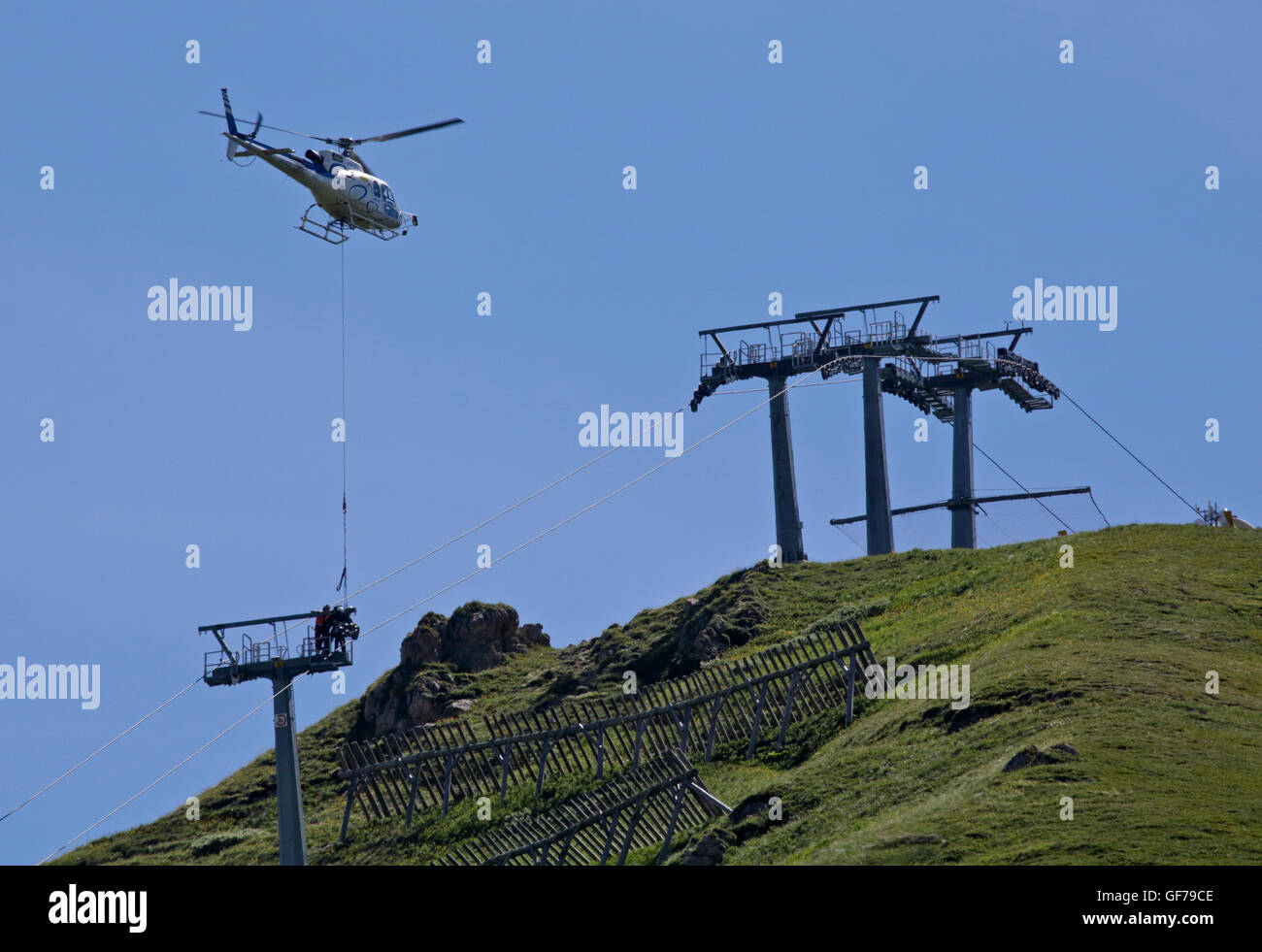 Elicottero cavo di sollevamento auto ruote a puleggia per costruzione, Passo Pordoi, Dolomiti, Italia Foto Stock