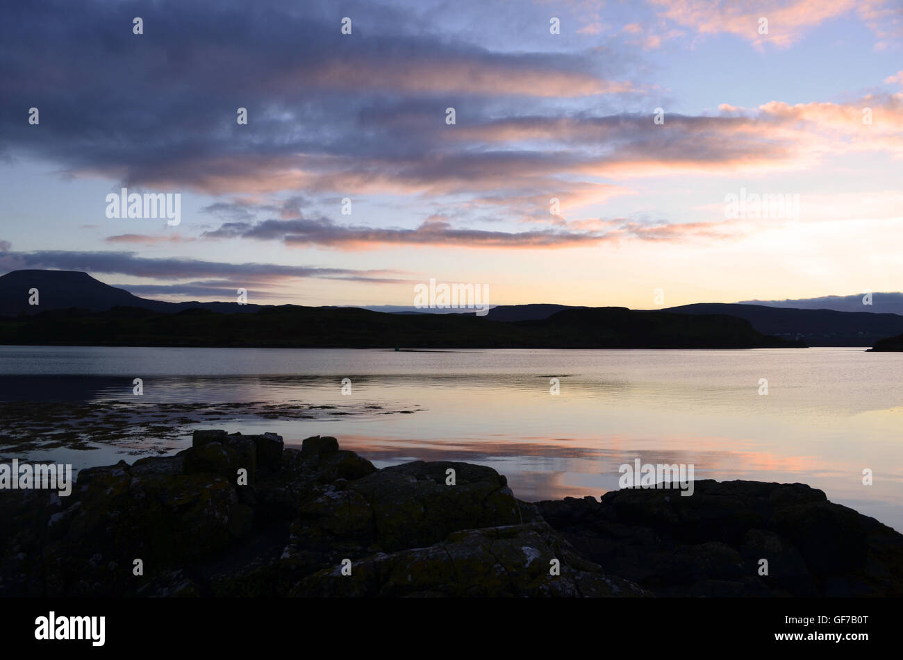 Splendido loch dunvegan con cieli rosa e i riflessi dell'acqua. Foto Stock