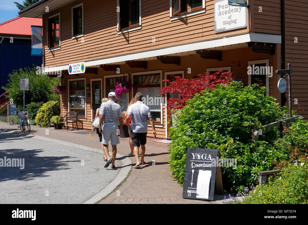 I turisti a piedi da un variopinto edificio in Piazza artigianale sull isola di Bowen, British Columbia, Canada Foto Stock