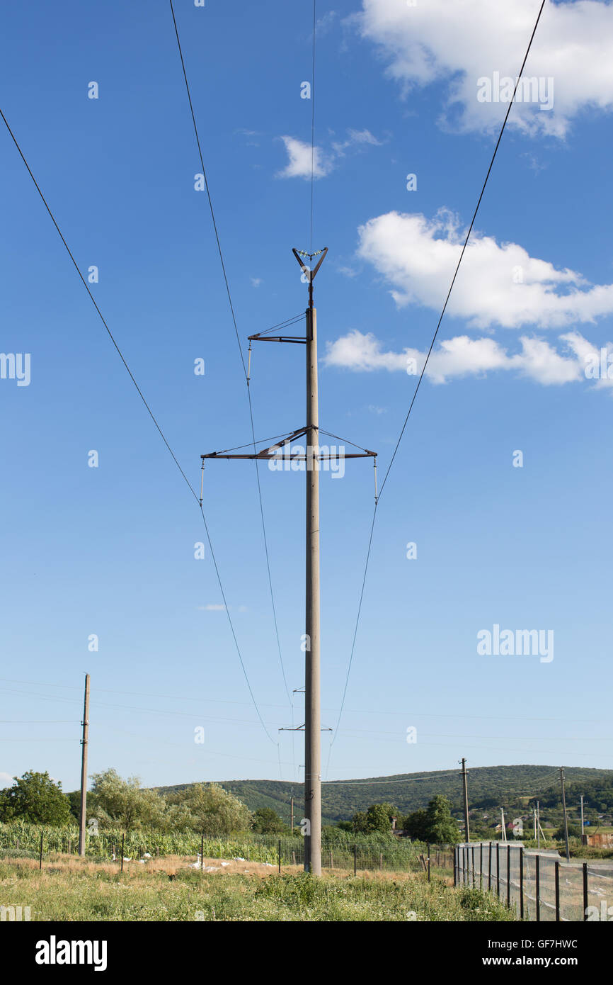 Alta tensione linea elettrica ferroviaria contro il cielo blu Foto Stock